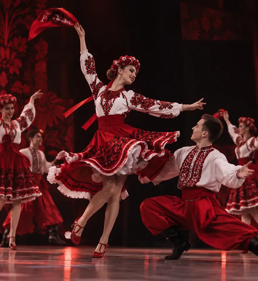 Народно-сценічний танець на сцені: танцівники у червоних строях